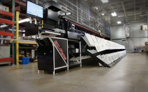 An EZ-Flats Premium Mail Sorting Machine sits in a warehouse with a blurry background