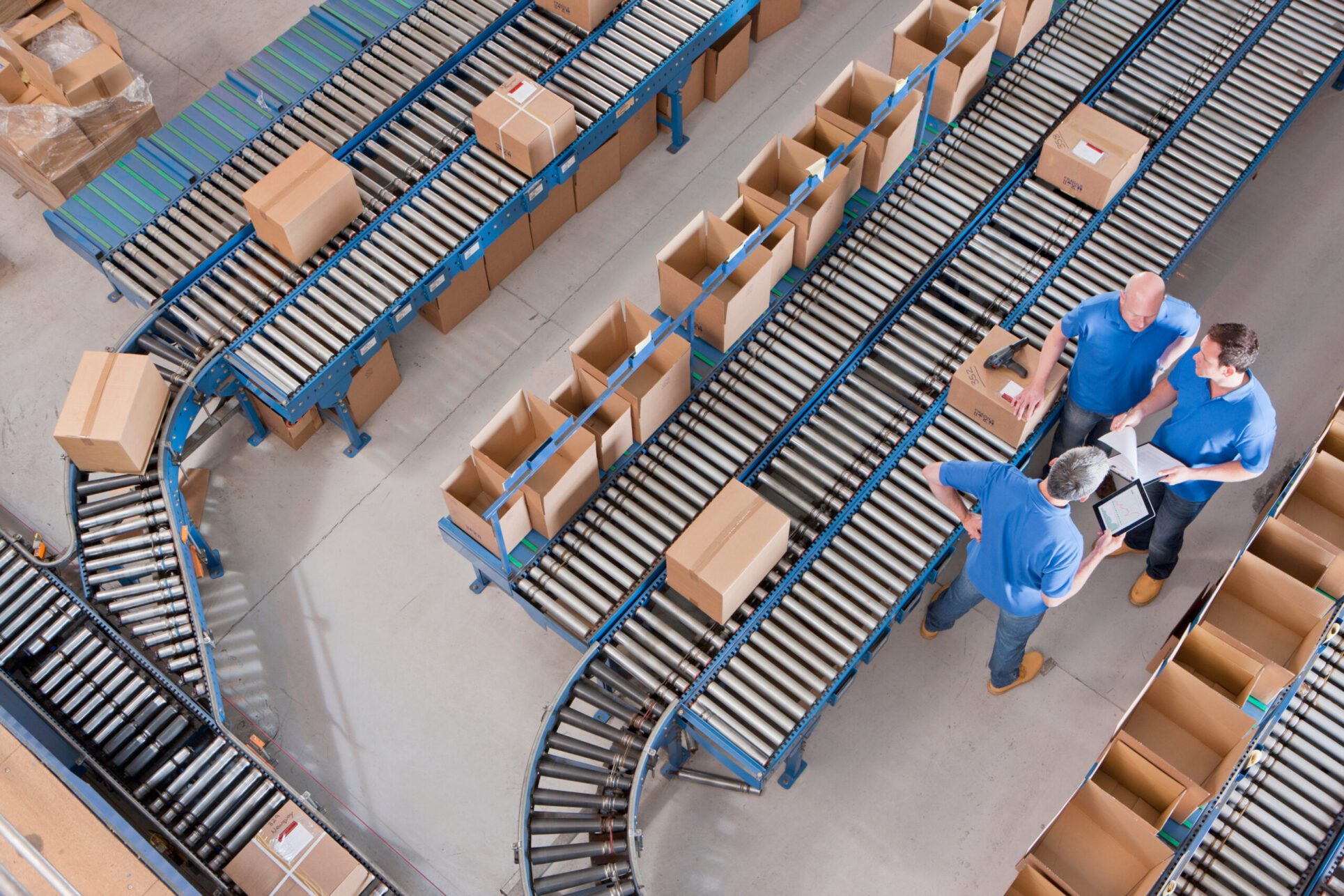 warehouse managers stand around conveyor belts